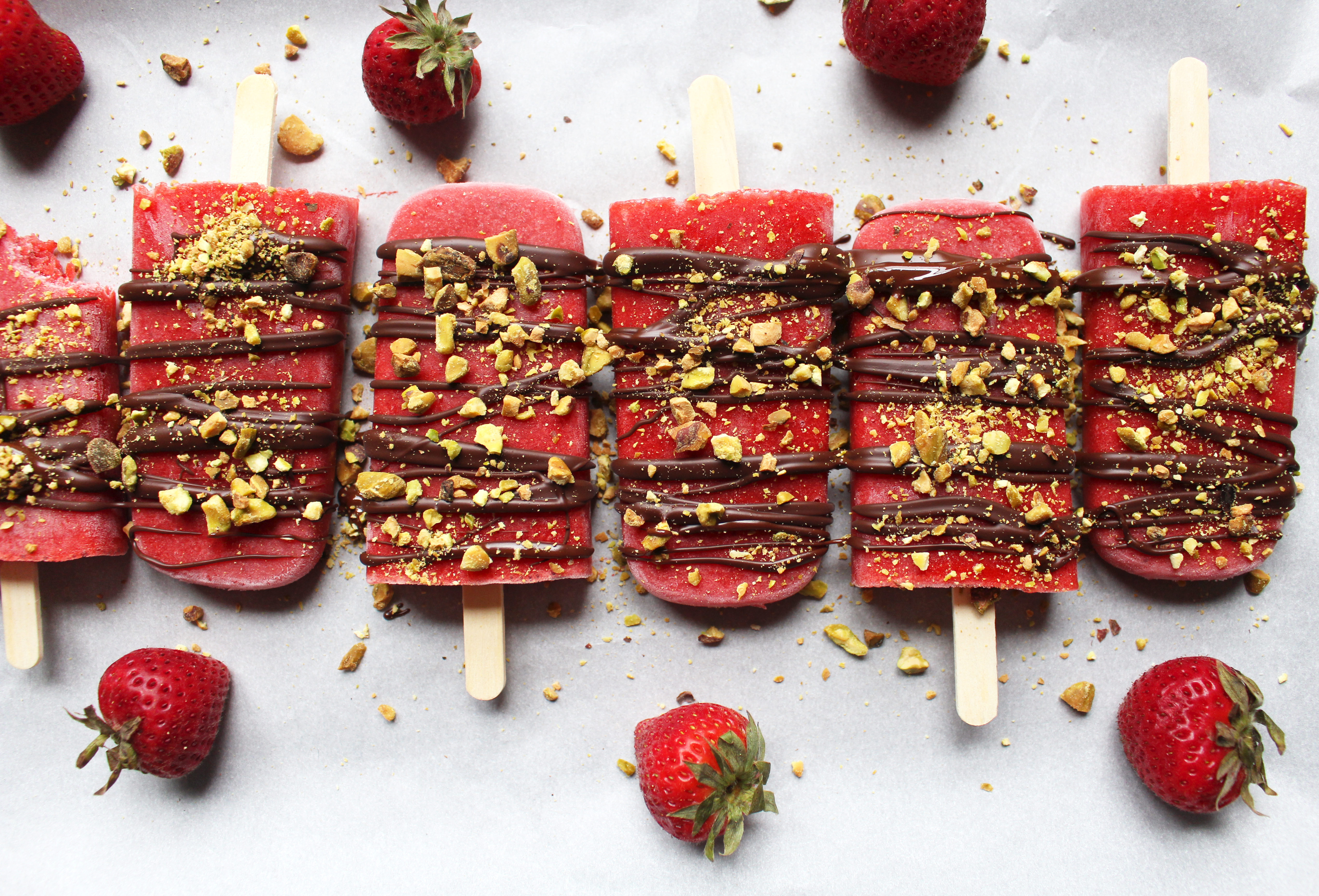 The juiciest strawberry popsicles with rose water and topped with chocolate and pistachios. The perfect sweet treat in summer! (GF, V, Refined sugar free)