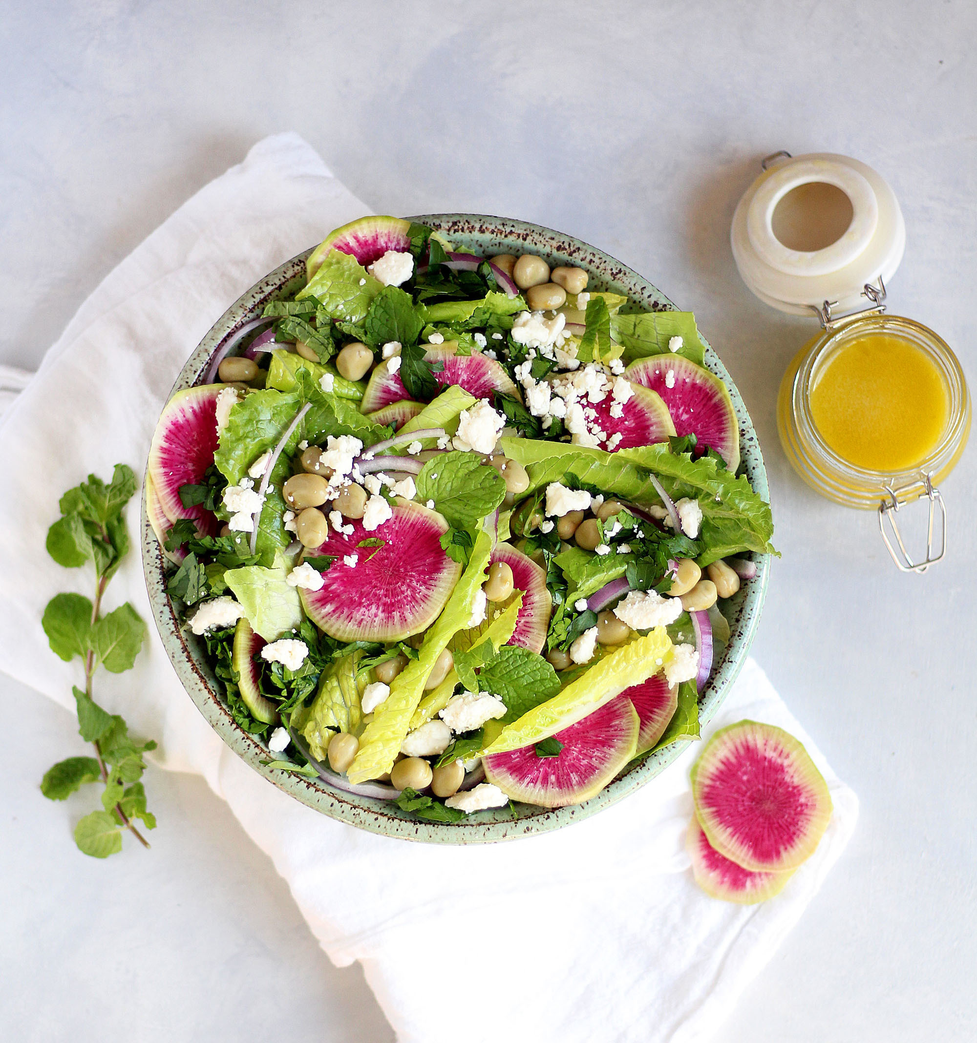 Crunchy romaine salad with fava beans, watermelon radishes, feta, and herbs. 